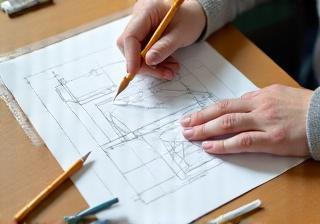 Hands drawing furniture plan